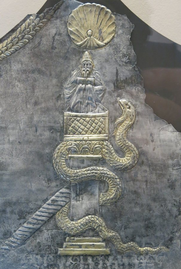 Placa de prata: um monge de barba no alto de uma coluna, sob uma concha, com uma serpente enrolada na coluna